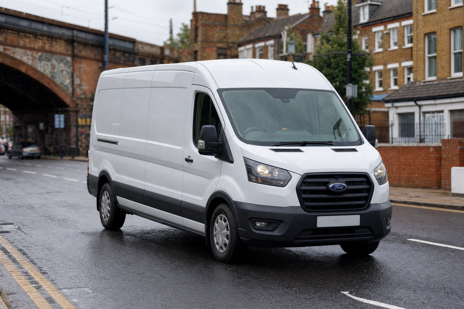 White delivery van driving on a wet Greater London road with UK lane markings